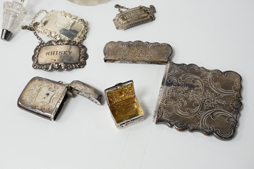 A small group of collectable silver including a Victorian engraved card case, Hilliard & Thomason, Birmingham, 1856, 10cm, three modern wine labels, a vesta case, a 925 pill box and an Edwardian mounted glass scent bottl